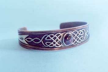 Copper and silver celtic bracelet with a garnet centre piece