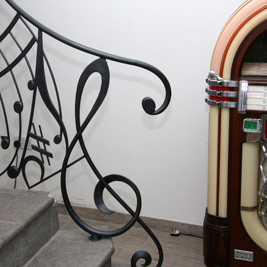Newel post based on treble clef with Wurlitzer in the background
