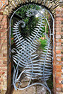 A garden gate made from fern sculptures