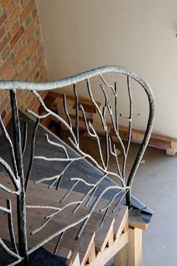 Flowing stair handrail forged steel bark texture
