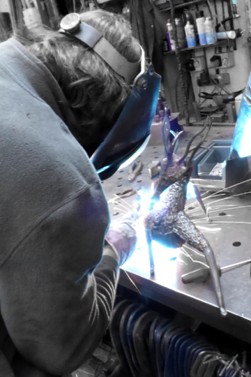 Welding a steel dragon sculpture