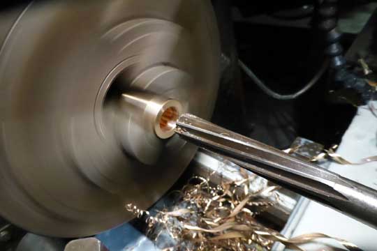 Reaming bronze door handles on a lathe