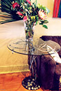 A table made from a twisted metal tree and fallen leaves