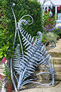 A garden gate made from fern sculptures