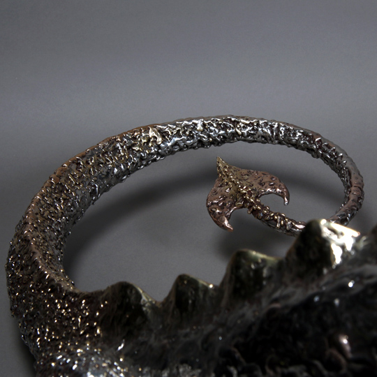 The dragon sculpture's polish enhances the beauty of the bronze and stainless steel used