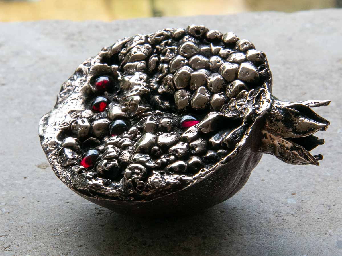 The bronze and garnet pomegrante sculpture is a response to the ancient greek myth of Persephones The bronze and garnet pomegrante sculpture is a response to the ancient greek myth of Persephones